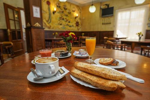 Hotel Colón في روندا: طاولة خشبية وصحون طعام وكوب قهوة