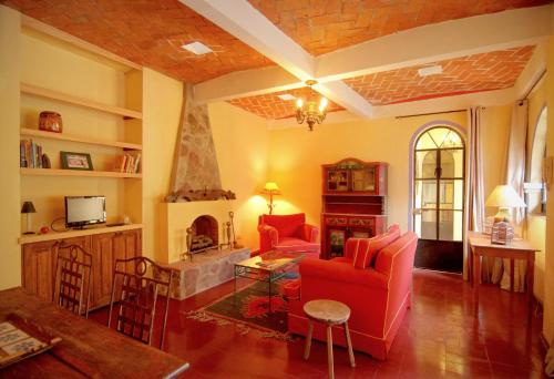 un soggiorno con divano rosso e camino di Casa de la Noche a San Miguel de Allende