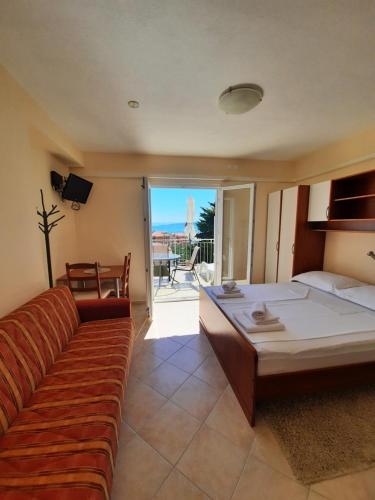a bedroom with a couch and a bed with a view at Palma Promajna Apartments in Promajna