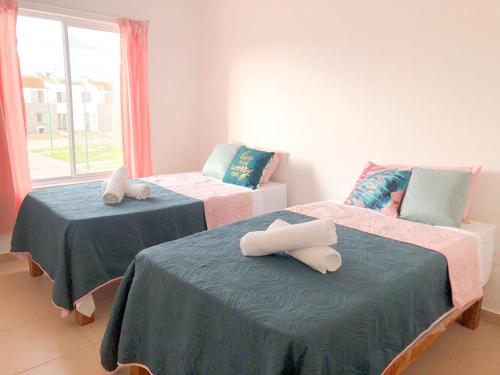 2 camas con toallas en una habitación en Modern Pool Side 3 Bedroom House, Puerto Vallarta, en Puerto Vallarta