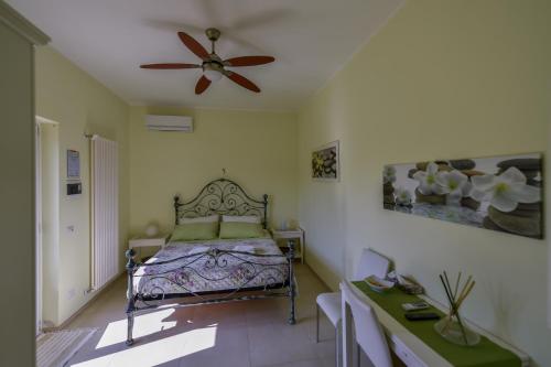 a bedroom with a bed and a ceiling fan at Albero Del Miglio in Torre a Mare