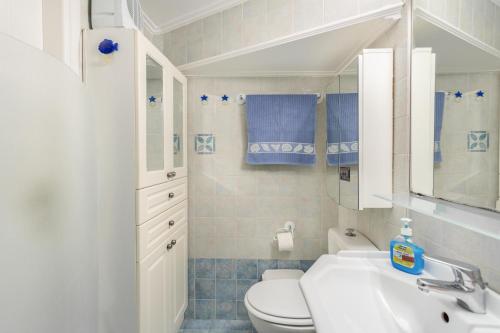 a bathroom with a white toilet and a sink at Villa Maya in Pallíni