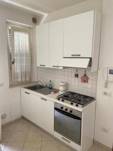 a kitchen with white cabinets and a stove top oven at Vacanze a Cupra Marittima in Cupra Marittima
