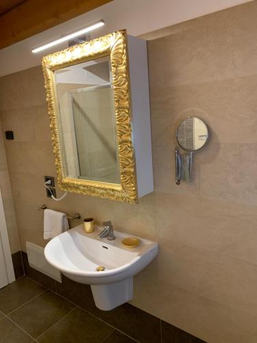 Villa Vaccari Garda في غارْدا: حمام مع حوض أبيض ومرآة