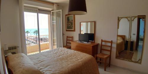 a bedroom with a bed and a view of the ocean at Appartamento Giardino in Ventimiglia