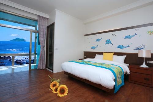 Un dormitorio con una cama con una pared con delfines en Jia Ying Beach Resort B&B en Toucheng