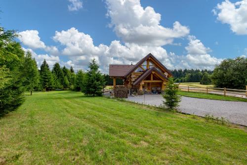 a log cabin in the middle of a grass field at KRALJICA ŠUME - Divjake Log Home in Hlevci