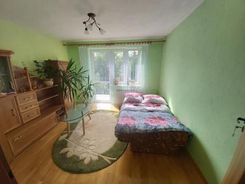 a bedroom with a bed and a table and a window at Apartament Berezka 667-108-706 in Polańczyk