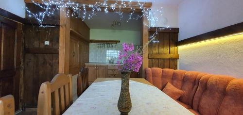 a table with a vase with purple flowers on it at Guest House Panorama in Gela