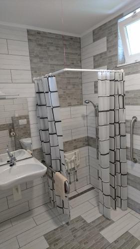 a bathroom with a shower and a sink at Bé-La 2 Vendégház in Szomolya