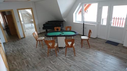 a room with a table and chairs and a piano at Bé-La 2 Vendégház in Szomolya