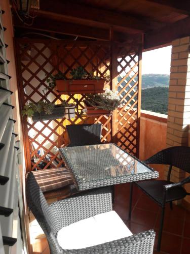 einen Tisch und Stühle auf einer abgeschirmten Veranda in der Unterkunft B&B Santa Barbara in Iglesias