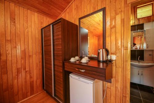 a kitchen with a counter and a sink and a mirror at Cirali Zakkum Bungalow in Cıralı