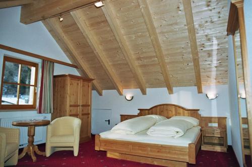 1 dormitorio con 1 cama con techo de madera en Hotel Garni Litzner en Ischgl