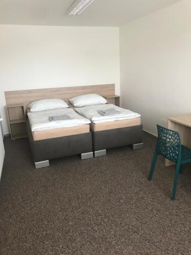 um quarto com duas camas e uma cadeira em Apartmánové ubytovanie em Vranov nad Topľou