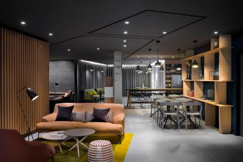 a living room with a couch and tables and a bar at Okko Hotels Nantes Château in Nantes