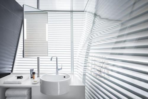 a bathroom with a white sink in front of a window at Okko Hotels Nantes Château in Nantes