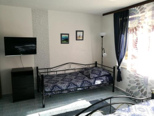 een slaapkamer met een bed en een flatscreen-tv bij Ferienhaus Bozena Appartment 2 in Vrsar