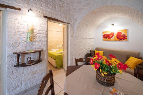 a room with a table with a vase of flowers on it at Trullo dal Cavaliere in Alberobello