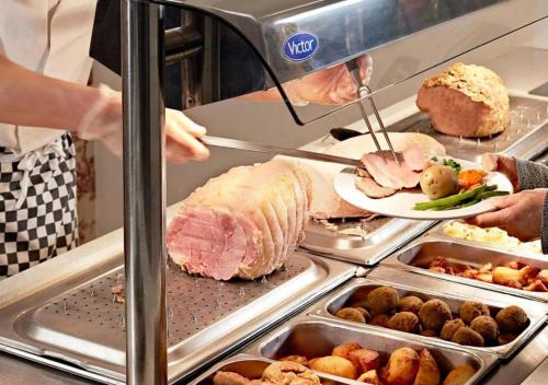 a person is preparing a sandwich in a buffet at The Bridge House; BW Signature Collection in Ferndown