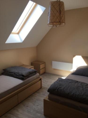 a bedroom with two beds and a skylight at Vendvidéki Pihenőházak in Felsőszölnök
