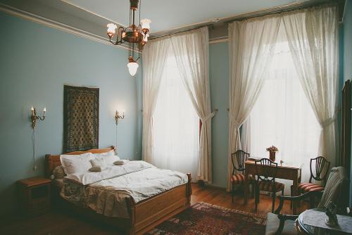 a bedroom with a bed and two large windows at Conac Polizu in Maxut