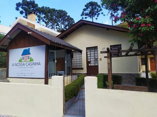 uma casa com um sinal em frente em A Nossa Casinha em Campos do Jordão