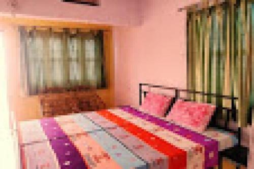 a bedroom with a bed with a colorful quilt on it at StayApart - The Himalayan Stay in Gopeshwar