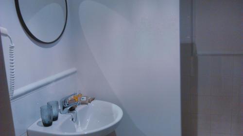 a white bathroom with a sink and a mirror at Hotel Rural El Secreto de Julia in Ríoseco