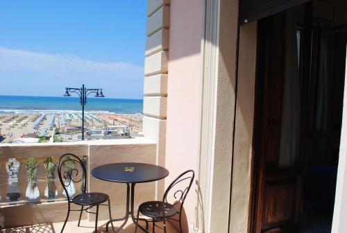 a balcony with a table and chairs and the ocean at Villa Tina Hotel in Viareggio