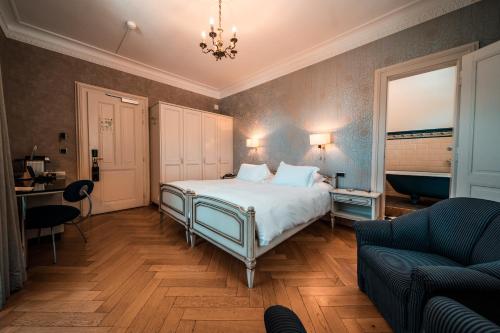 a bedroom with a bed and a couch at Royal St. Georges Hotel Interlaken - MGallery Collection in Interlaken