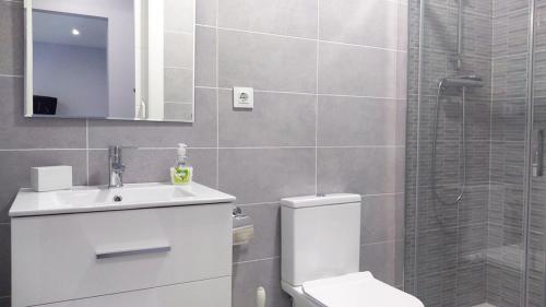 een badkamer met een toilet, een wastafel en een douche bij Apartamento los Acantilados Nº 2 Cobreces in Cóbreces