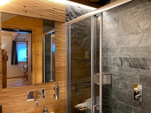 a bathroom with a glass shower and a mirror at Hotel Centrale in Peio