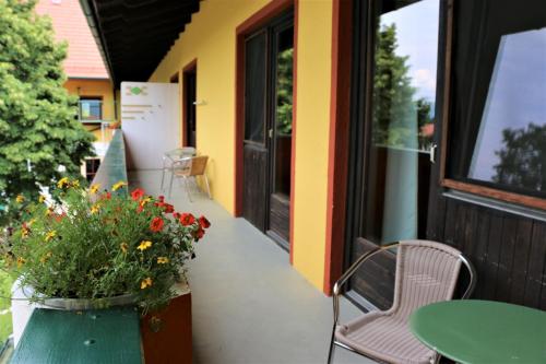 a patio with a table and a chair and flowers at Werkhof Bistrica in Hof