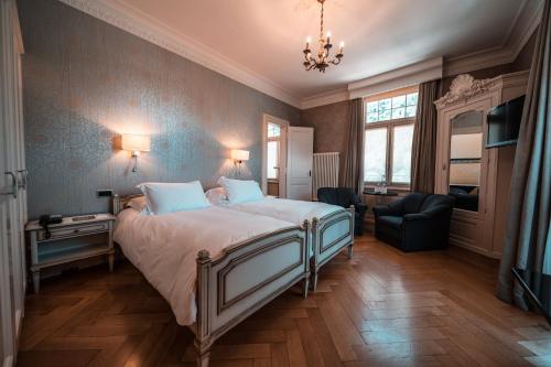 a bedroom with a bed and a chandelier at Royal St. Georges Hotel Interlaken - MGallery Collection in Interlaken