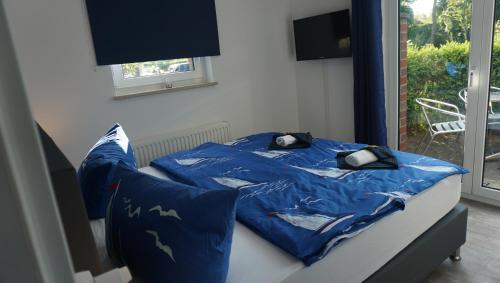 Bett mit blauer Bettdecke und Kissen in der Unterkunft kuebo-ferien Wohnung 6 in Kühlungsborn