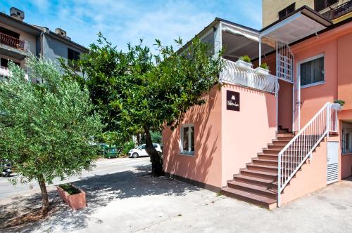 un edificio rosa con escaleras en una calle en bed&breakfast Bohemian, en Rovinj