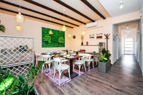 a restaurant with tables and chairs and a green wall at bed&breakfast Bohemian in Rovinj