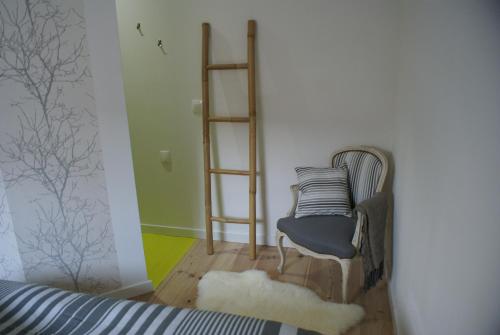 um quarto com uma cadeira e prateleiras num quarto em La Cour Soubespin em Lille