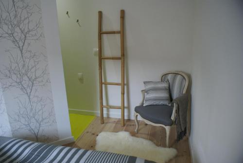 une chambre avec une chaise et des étagères dans l'établissement La Cour Soubespin, à Lille