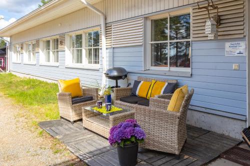 eine Terrasse mit Korbstühlen und einem Tisch auf einem Haus in der Unterkunft Kuukkeli Saariselkä Inn in Saariselkä