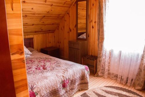 a bedroom with a bed in a wooden cabin at Шале " Компанійське" in Slavske