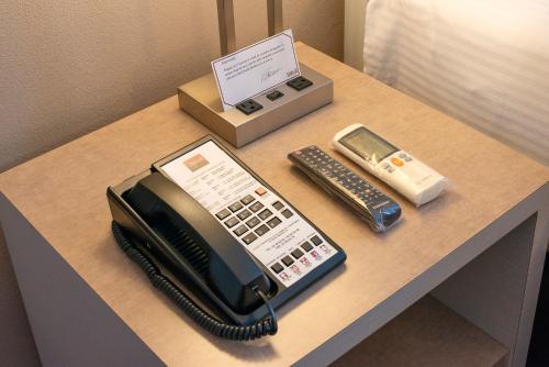 a desk with a telephone and a cell phone at Stanza Hotel in Mexico City