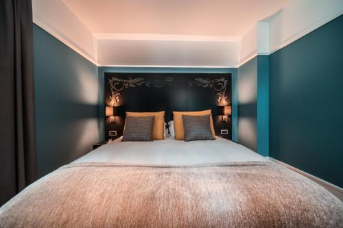 a bedroom with a large bed with blue walls at Royal St. Georges Hotel Interlaken - MGallery Collection in Interlaken