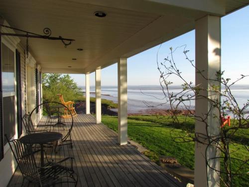 a porch with chairs and a view of the ocean at Cresthaven By the Sea in South Maitland