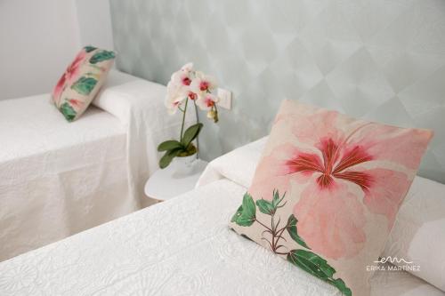 Habitación con 2 camas, almohada rosa y flores en MRZ Rentals Jerez Estación, en Jerez de la Frontera
