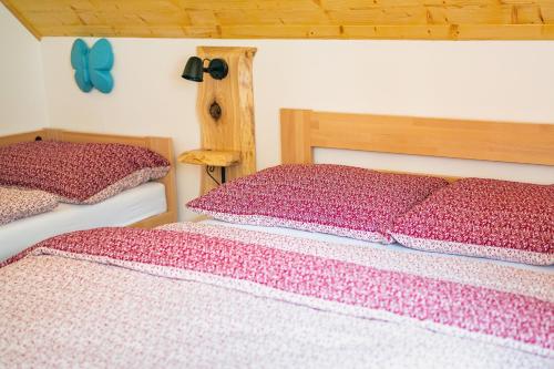 a bedroom with two beds with red and white sheets at Apartmány pod Rozsutcom - Zaťkov dvor in Terchová