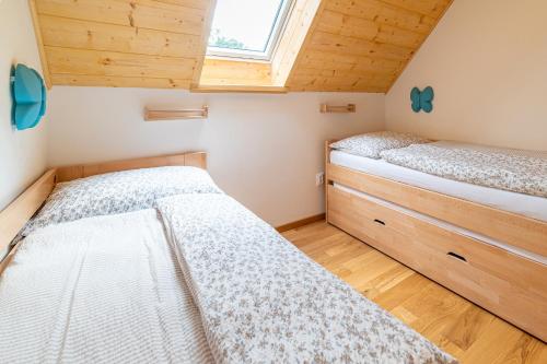 two beds in a small room with a window at Apartmány pod Rozsutcom - Zaťkov dvor in Terchová