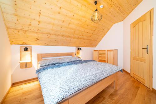 a bedroom with a bed and a wooden ceiling at Apartmány pod Rozsutcom - Zaťkov dvor in Terchová
