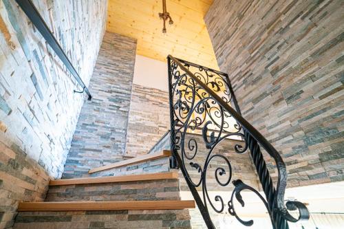 a staircase with a wrought iron railing in a building at Apartmány pod Rozsutcom - Zaťkov dvor in Terchová
